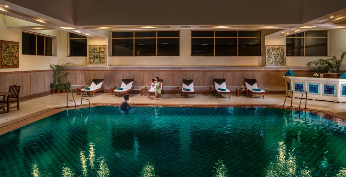 a pool in a hotel with people standing around it at Jaypee Residency Manor in Mussoorie