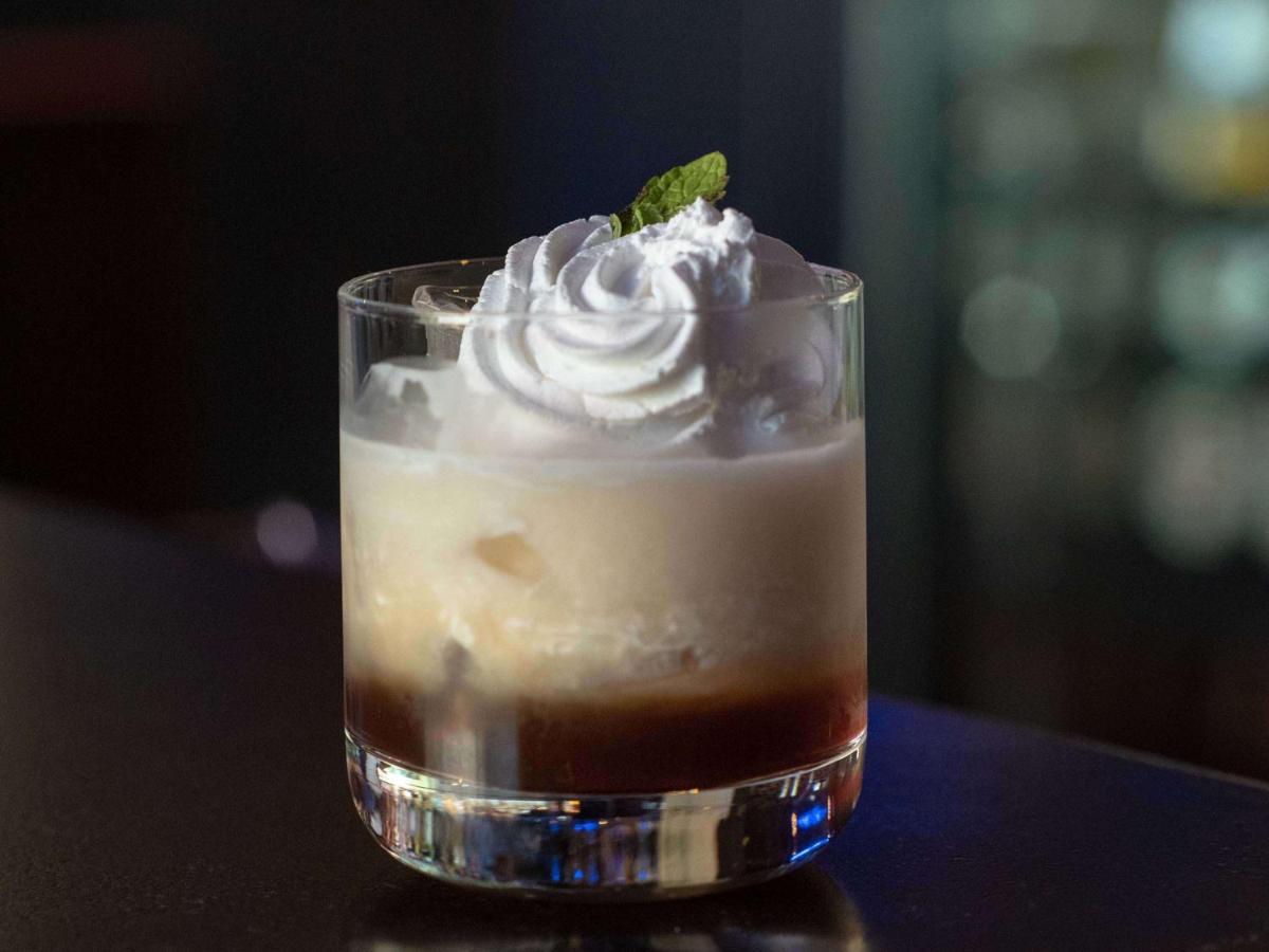 a drink with whipped cream and a mint leaf on top at Mercure Hyderabad KCP Banjara Hills, An Accor Hotel in Hyderabad