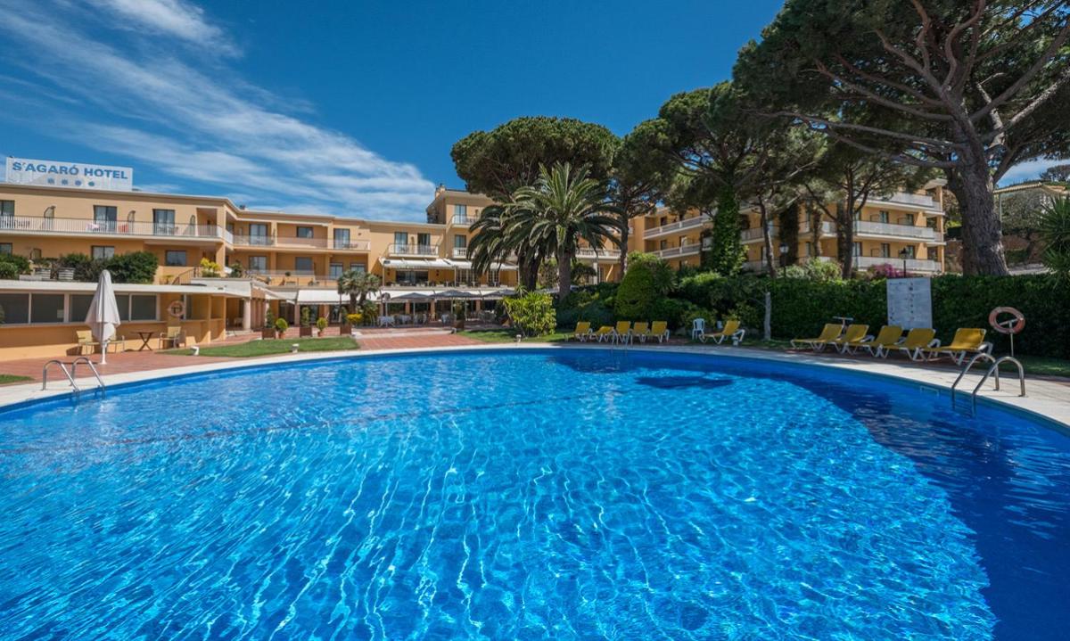 una gran piscina frente a un hotel en S'Agaró Hotel Spa & Wellness, en S'Agaró