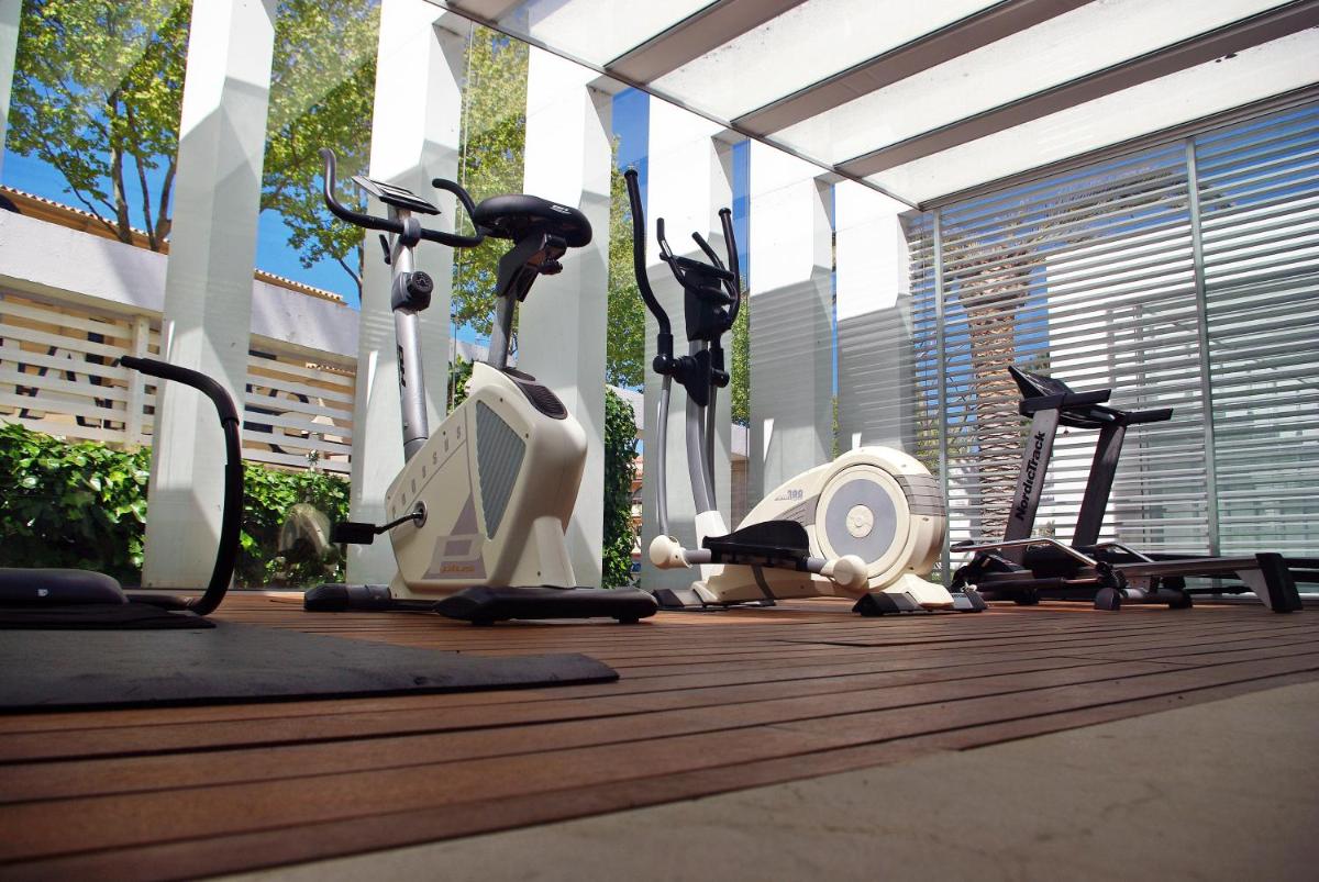 un gimnasio con varios equipos de ejercicio en una terraza en S'Agaró Hotel Spa & Wellness, en S'Agaró