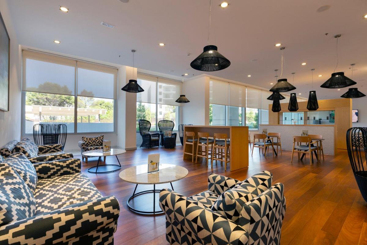 Una sala de estar con sofás y una mesa y sillas. en Hipotels Gran Playa de Palma, en Playa de Palma