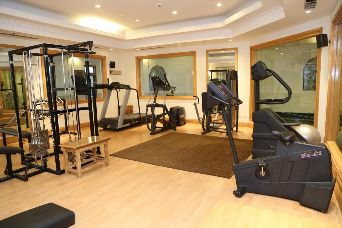 a gym with treadmills and ellipticals in a room at Jaypee Residency Manor in Mussoorie