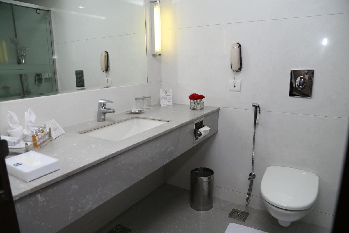 a bathroom with a sink and a toilet and a phone at Jaypee Residency Manor in Mussoorie