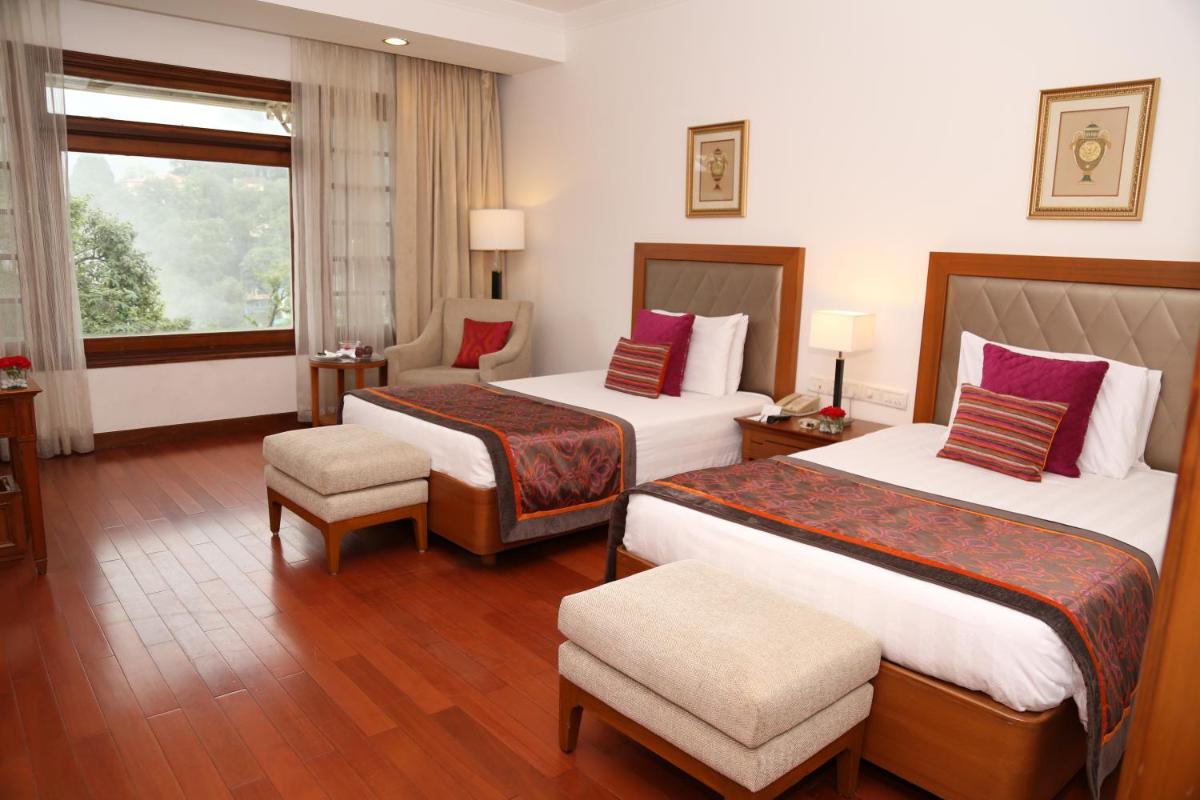 a hotel room with two beds and a window at Jaypee Residency Manor in Mussoorie
