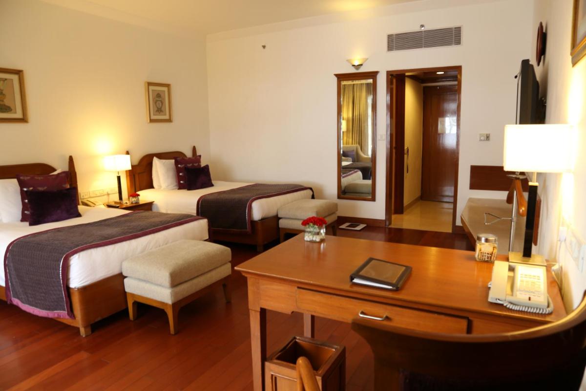 a hotel room with two beds and a desk at Jaypee Residency Manor in Mussoorie