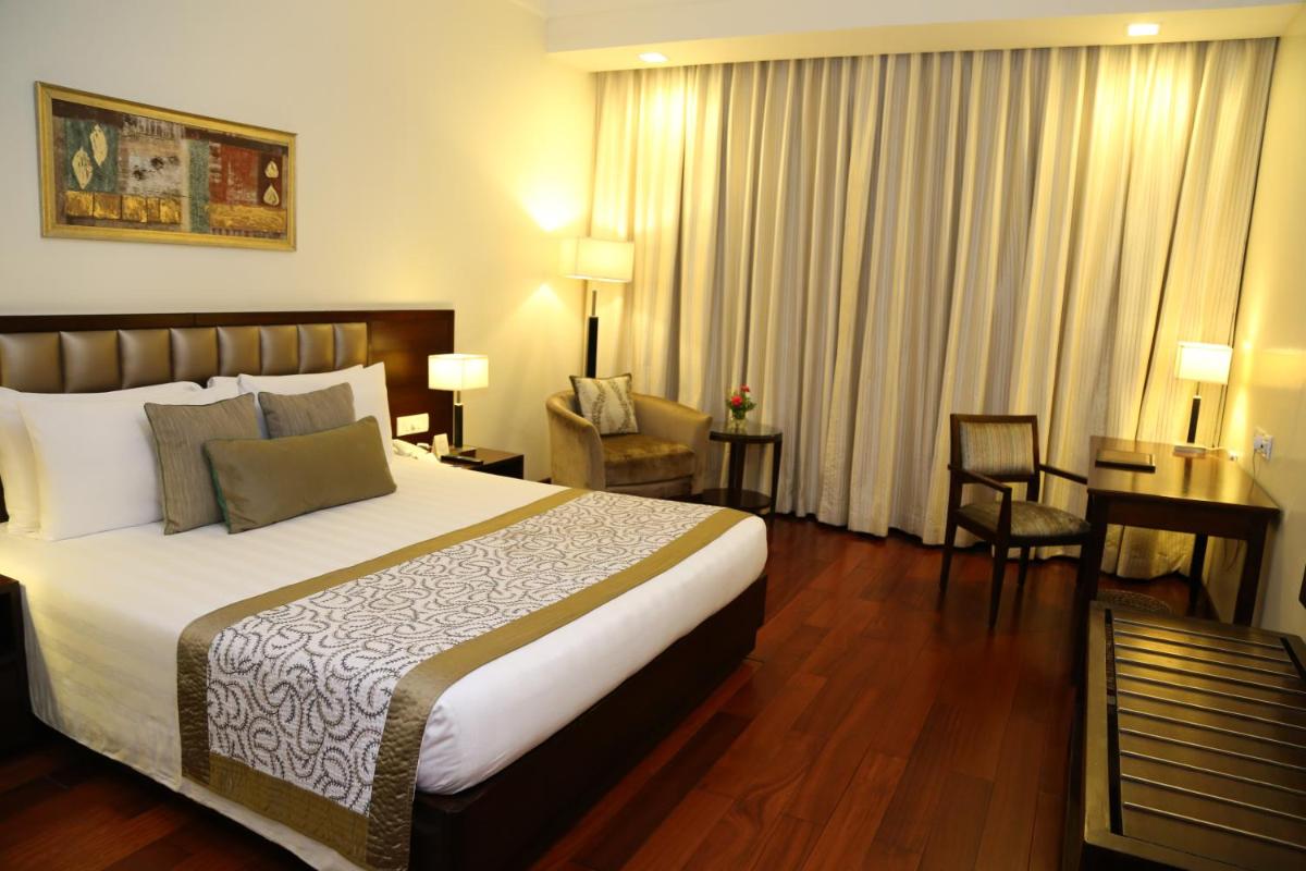a hotel room with a large bed and a desk at Jaypee Residency Manor in Mussoorie