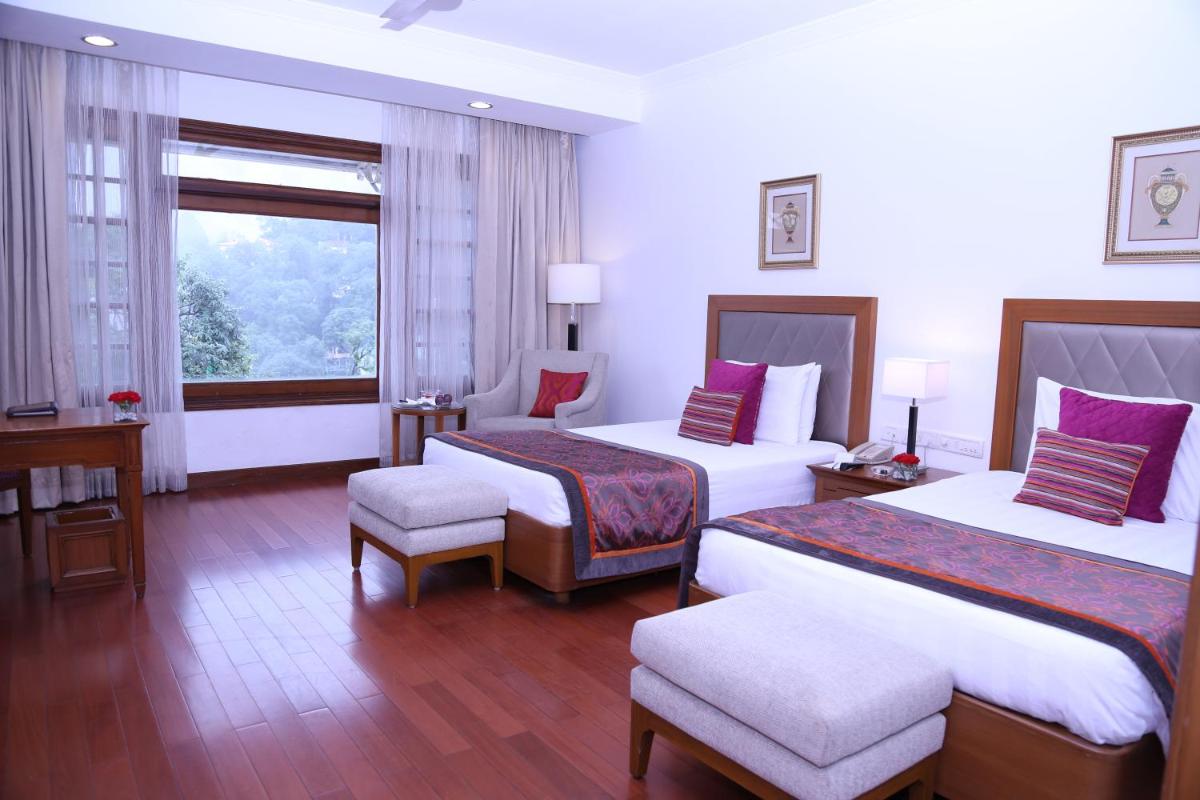 a hotel room with two beds and a window at Jaypee Residency Manor in Mussoorie