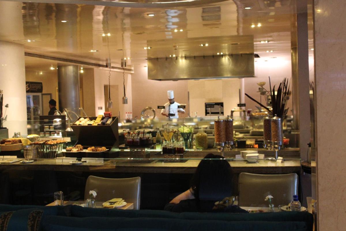 a restaurant with a counter with a chef in the kitchen at Blue Diamond Pune IHCL SeleQtions in Pune