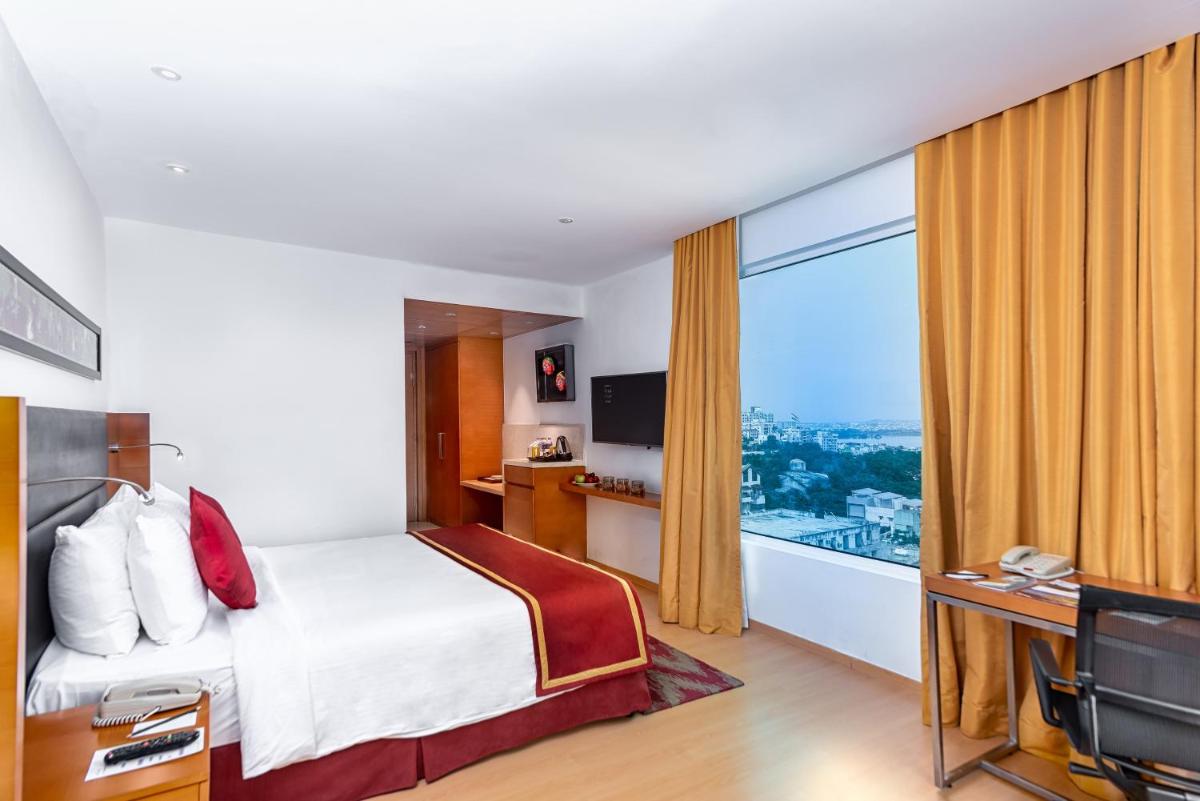 a hotel room with a bed and a large window at Mercure Hyderabad KCP Banjara Hills, An Accor Hotel in Hyderabad