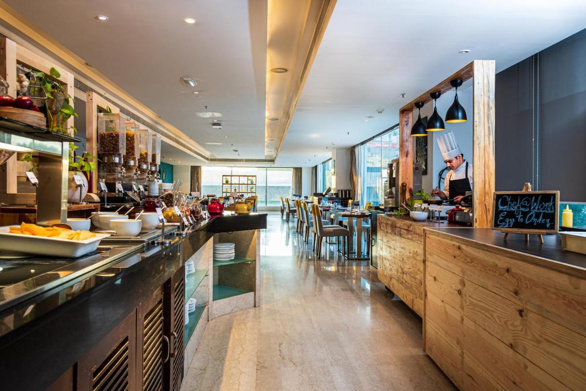 a restaurant with a bar with tables and chairs at Mercure Hyderabad KCP Banjara Hills, An Accor Hotel in Hyderabad