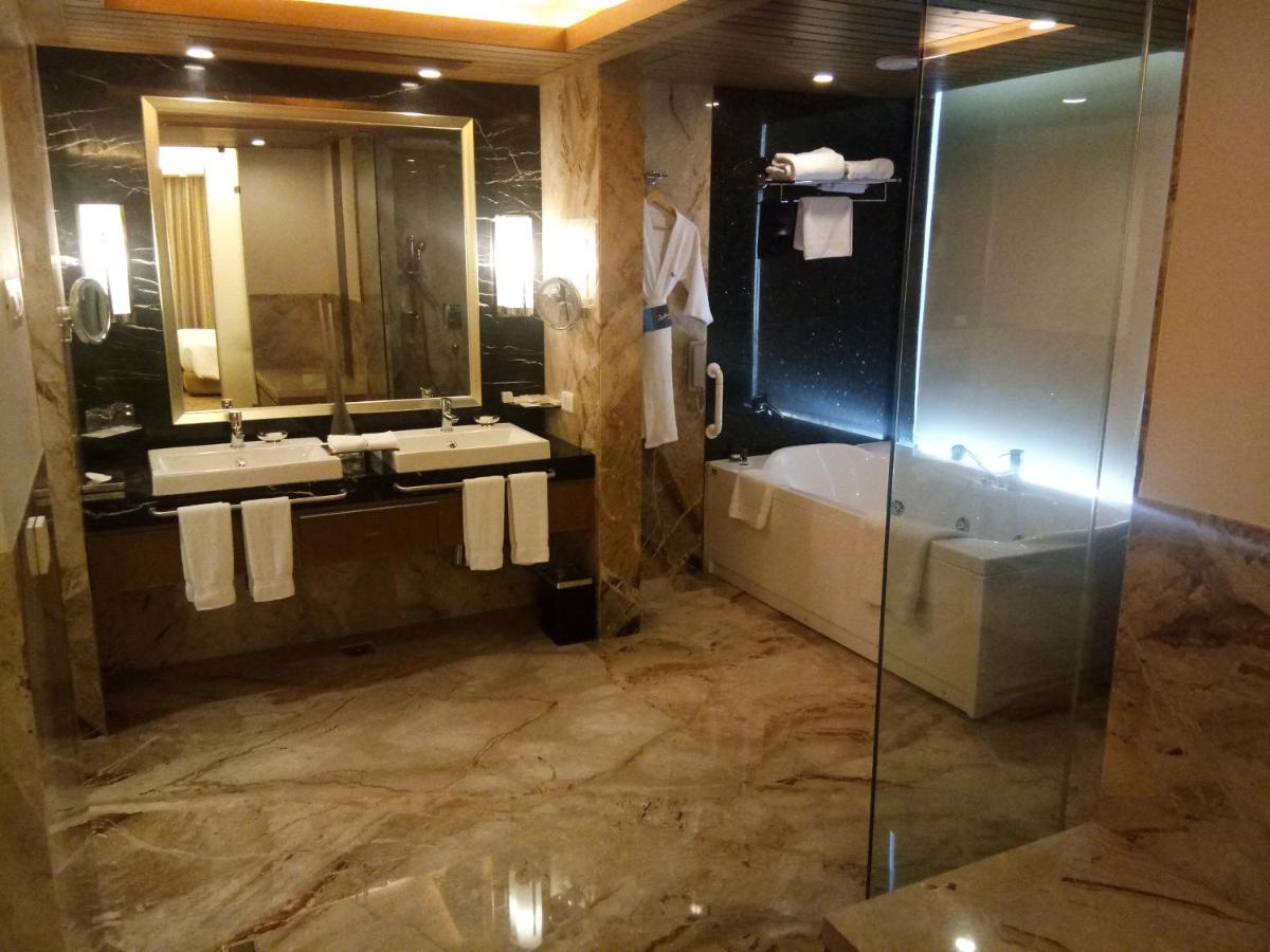 a bathroom with a tub and a sink and a shower at Radisson Blu Hotel, Nagpur in Nagpur