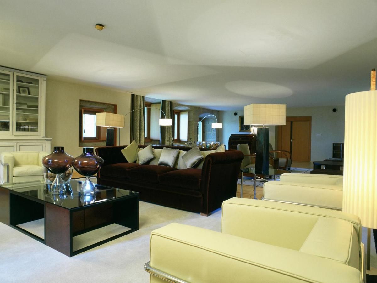 una sala de estar con un sofá y una mesa en Parador de Santo Estevo, en Santo Estevo de Rivas de Sil