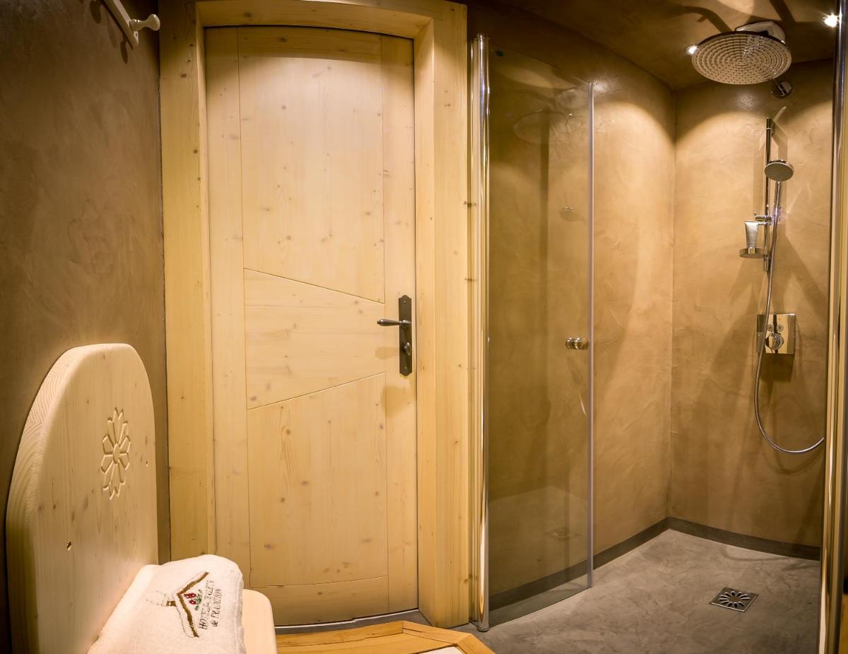 une salle de bain avec douche et porte vitrée dans l'établissement Hotel & Spa Le Dahu, à Morzine