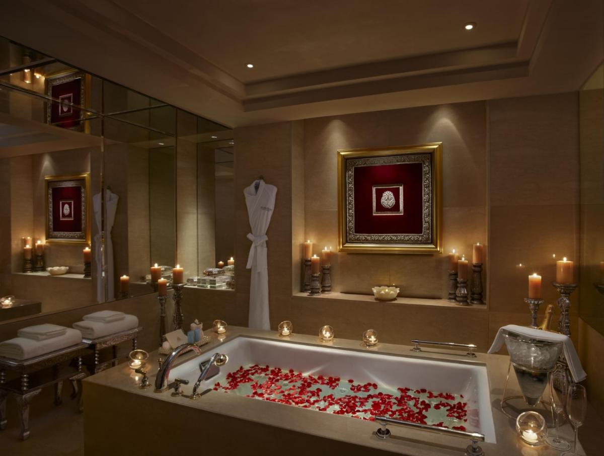 a bathroom with a bath tub filled with red roses at The Leela Palace Udaipur in Udaipur