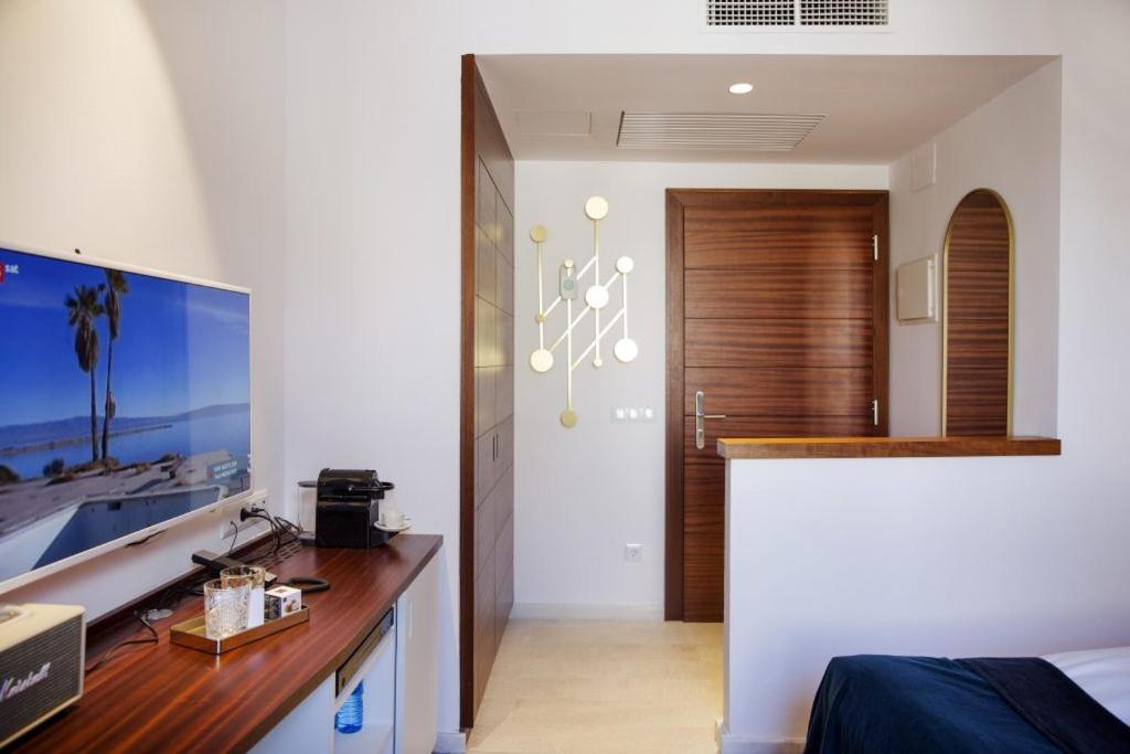 Un dormitorio con un escritorio y una habitación con una cama. en Portixol Hotel & Restaurant, en Palma de Mallorca