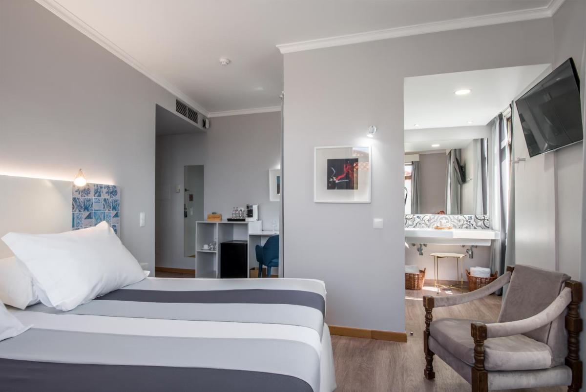 um quarto de hotel com uma cama e uma sala de estar em Sé Boutique Hotel no Funchal