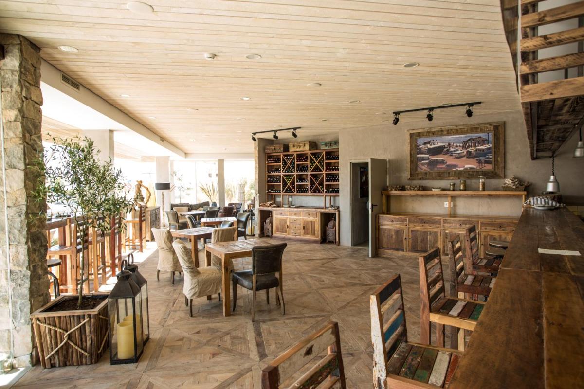 um restaurante com tectos e mesas e cadeiras de madeira em Surfers Lodge Peniche em Peniche
