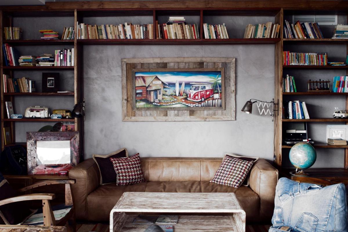 uma sala de estar com um sofá e prateleiras de livros em Surfers Lodge Peniche em Peniche
