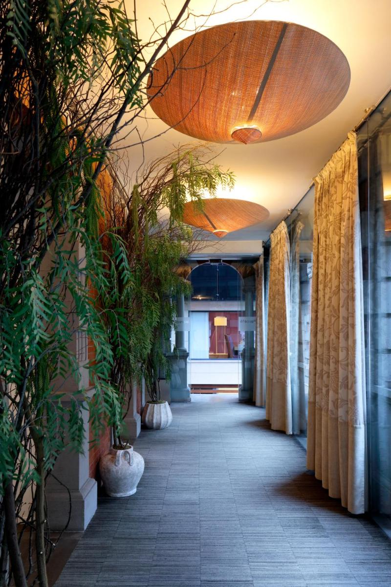 Un pasillo con plantas en macetas en un edificio. en Barceló Oviedo Cervantes, en Oviedo