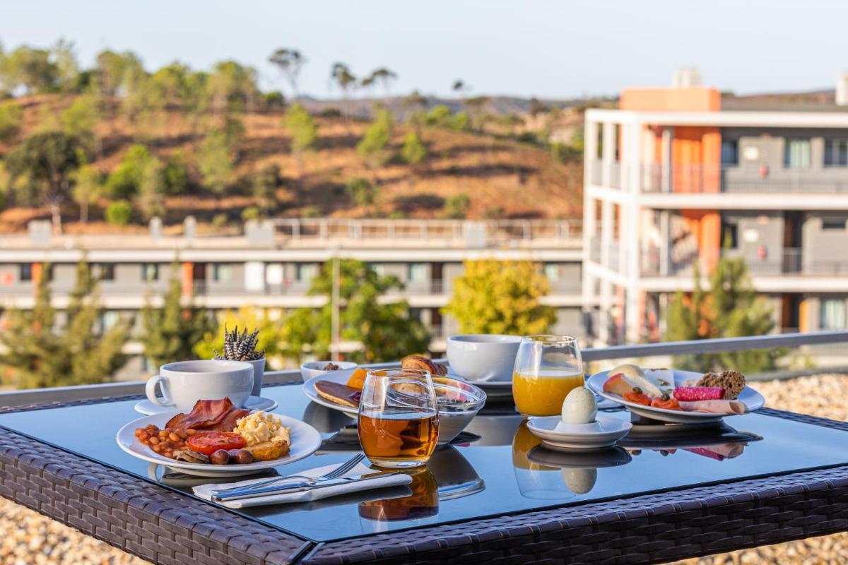 uma bandeja de comida numa mesa com bebidas e alimentos em Algarve Race Resort - Hotel em Montes de Cima