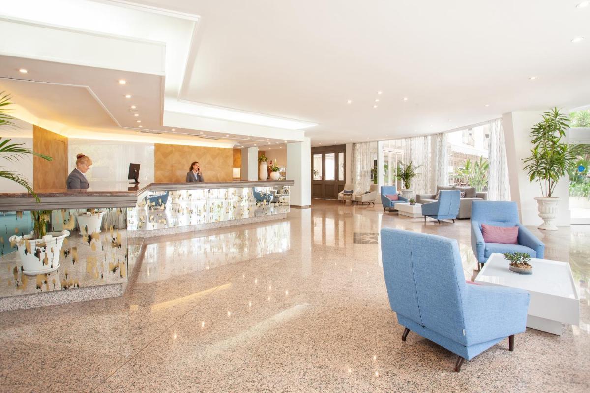 un vestíbulo con bar y sillas azules en Grupotel Orient, en Playa de Palma 39 fotos más