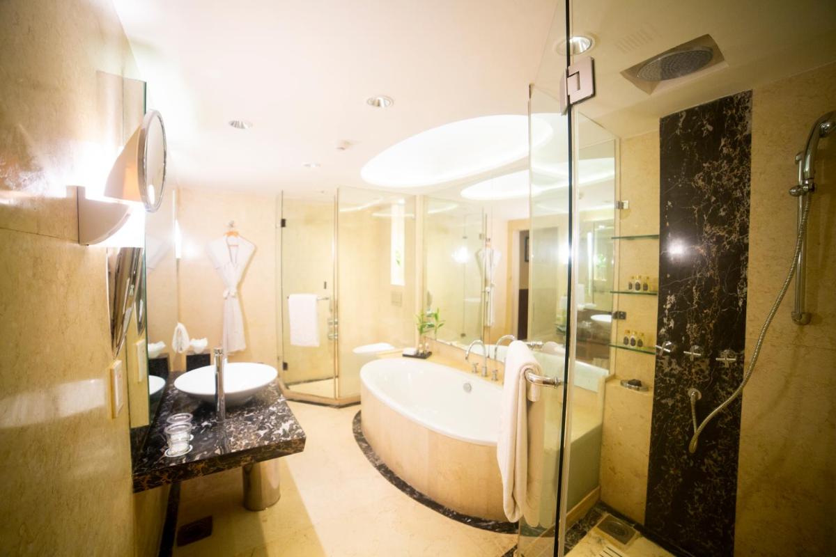 a large bathroom with a tub and a shower at Taj Club House in Chennai