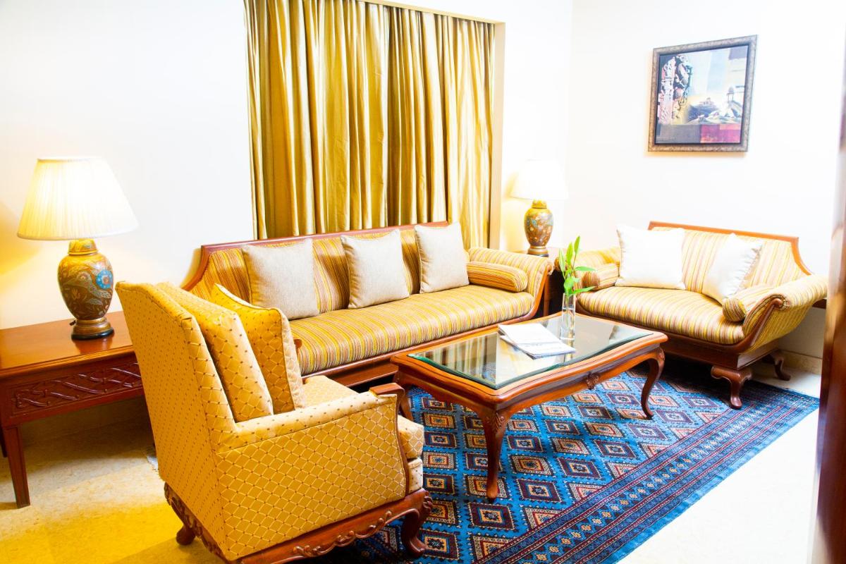 a living room with two couches and a coffee table at Taj Club House in Chennai