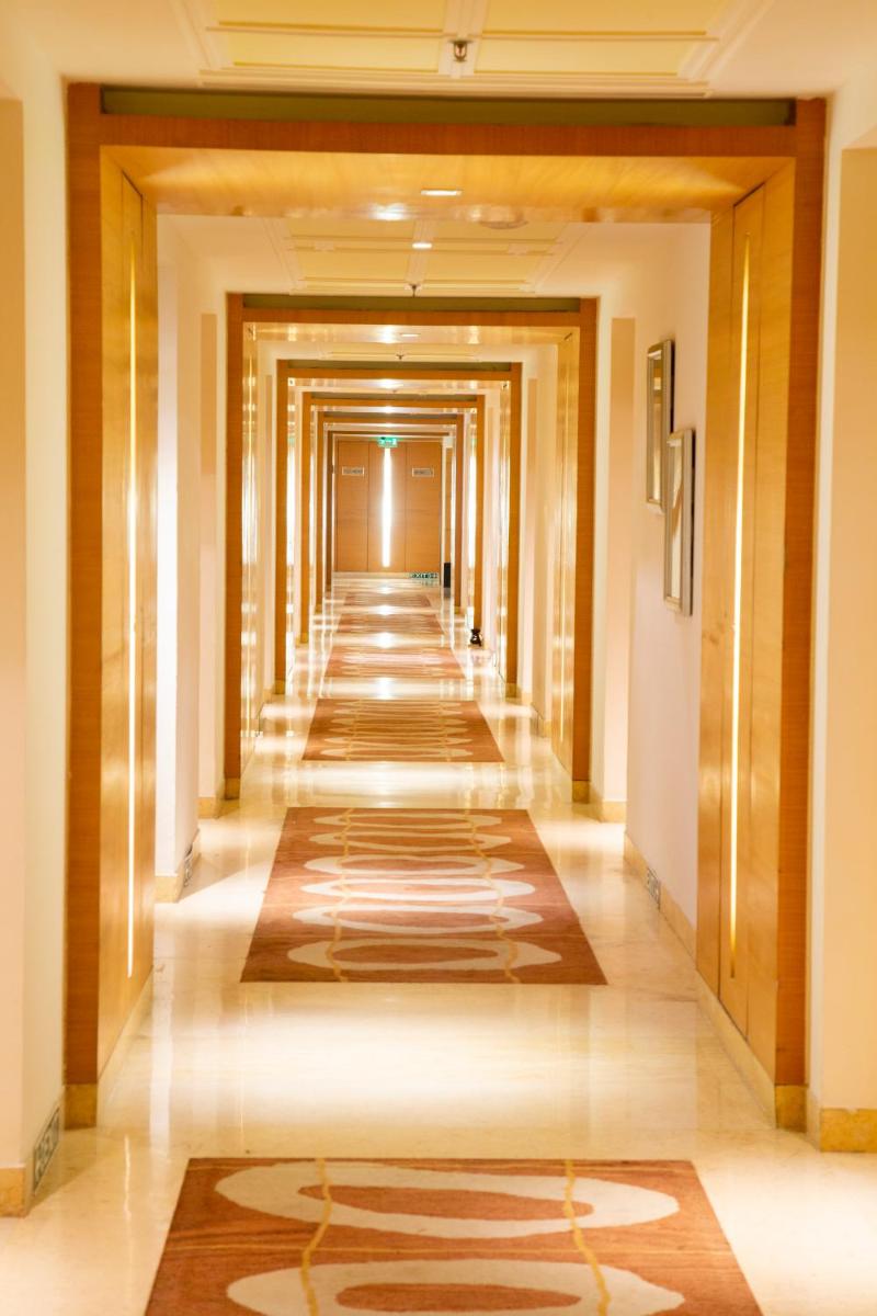 a corridor of a hotel with a long hallway at Taj Club House in Chennai
