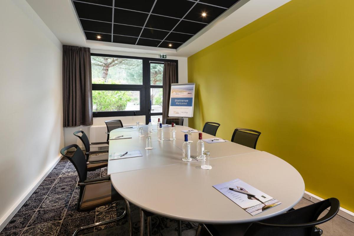 une salle de conférence avec une grande table blanche et des chaises dans l'établissement Thalazur Arcachon, à Arcachon 106 autres photos