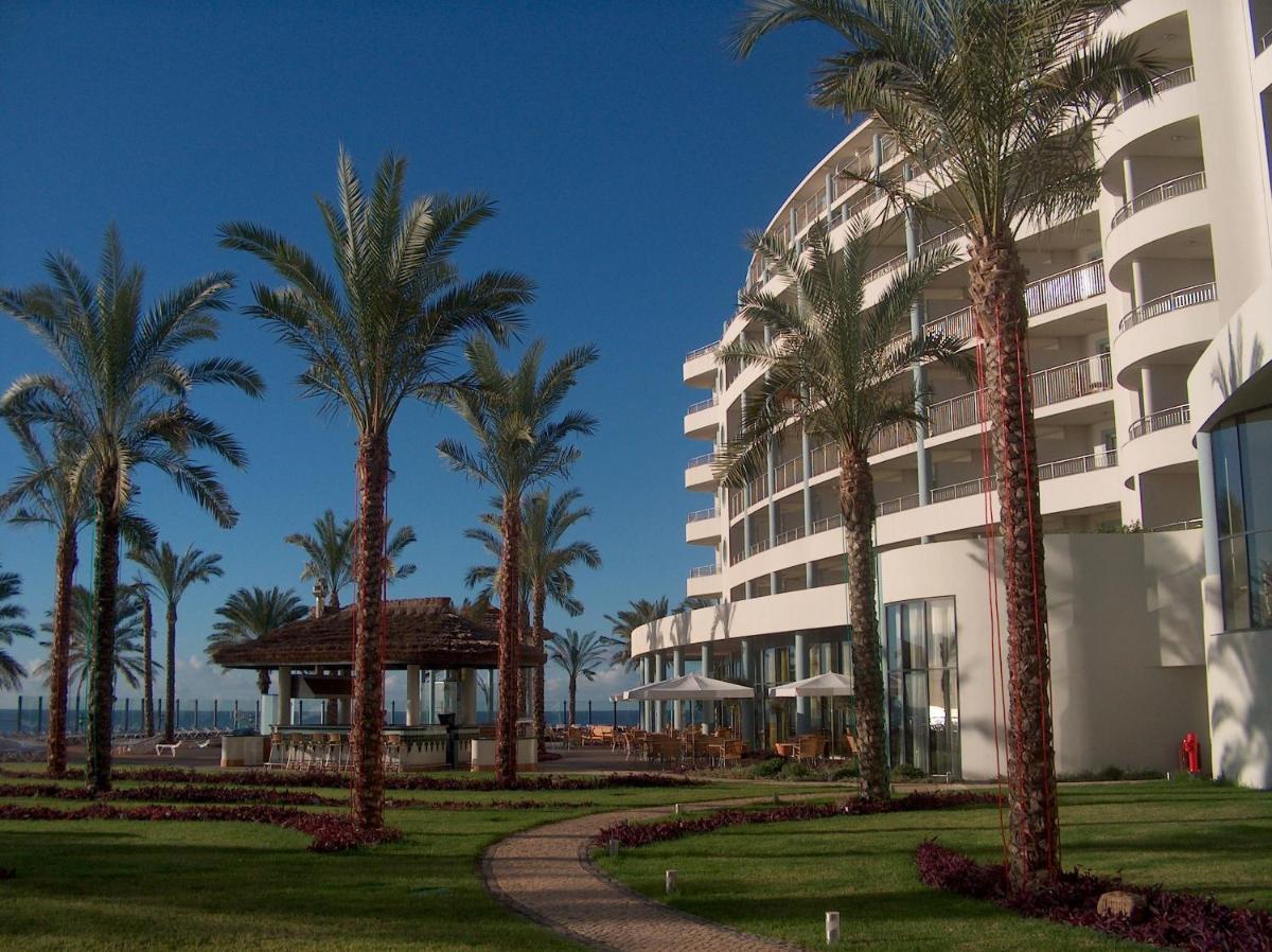 um prédio com palmeiras na frente em Pestana Grand Ocean Resort Hotel no Funchal