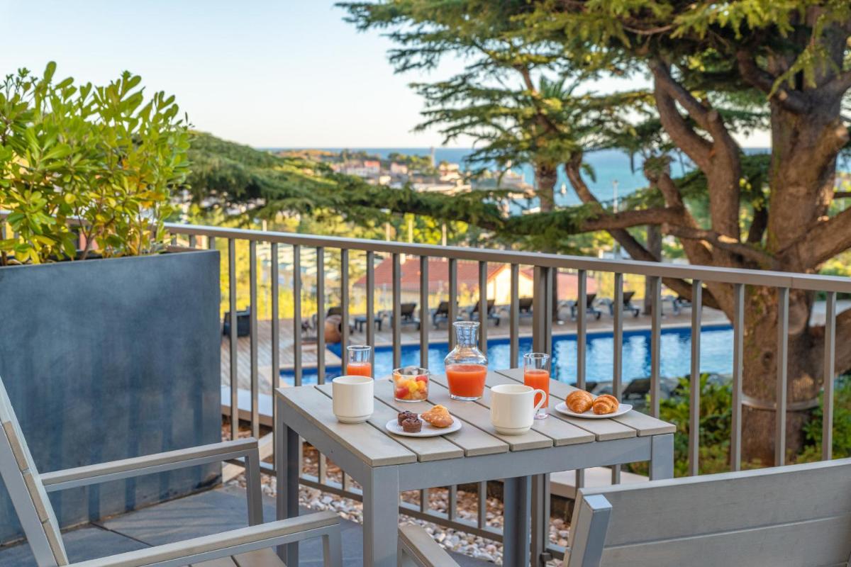 une table avec de la nourriture et des boissons sur un balcon dans l'établissement Les Jardins du Cèdre, Boutique hôtel & gastronomie, à Port-Vendres