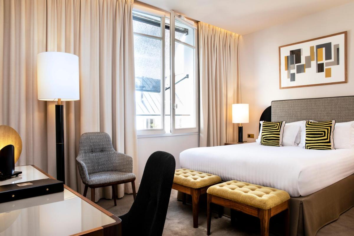 une chambre d'hôtel avec un lit, un bureau et une chaise dans l'établissement Le Tsuba Hotel, à Paris