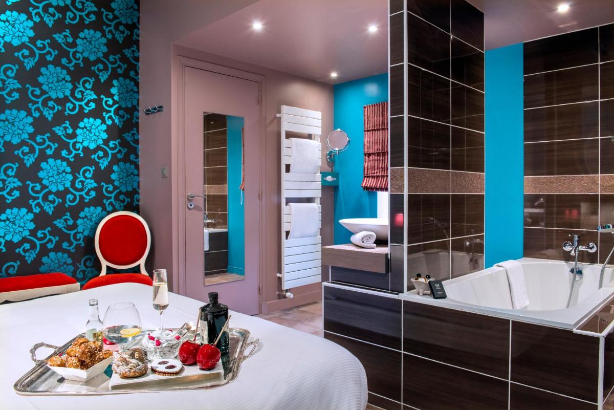 - une salle de bains avec baignoire et un lit avec plateau/bouilloire dans l'établissement Frédéric Carrion - Cuisine, Hôtel & Spa, à Viré