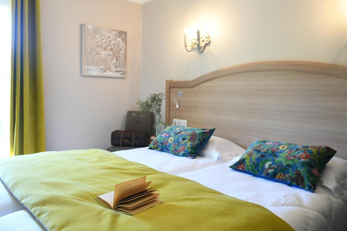 - une chambre avec un lit et un livre dans l'établissement Hôtel Villa Glanum et Spa, à Saint-Rémy-de-Provence