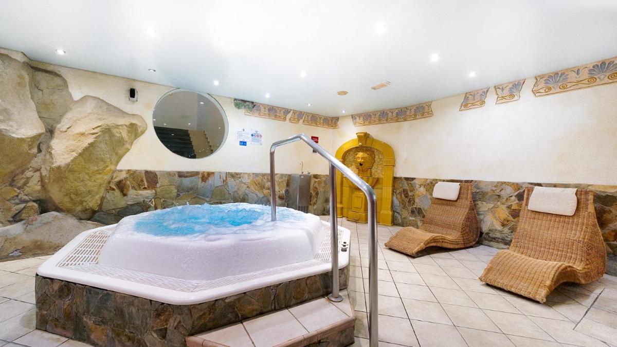 baño con bañera en una habitación con pared de roca en Bull Eugenia Victoria & SPA, en Playa del Inglés