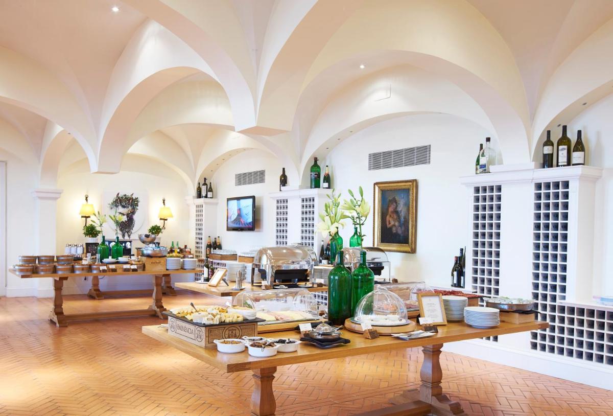 um quarto amplo com uma mesa com comida e garrafas de vinho em The Yeatman em Vila Nova de Gaia