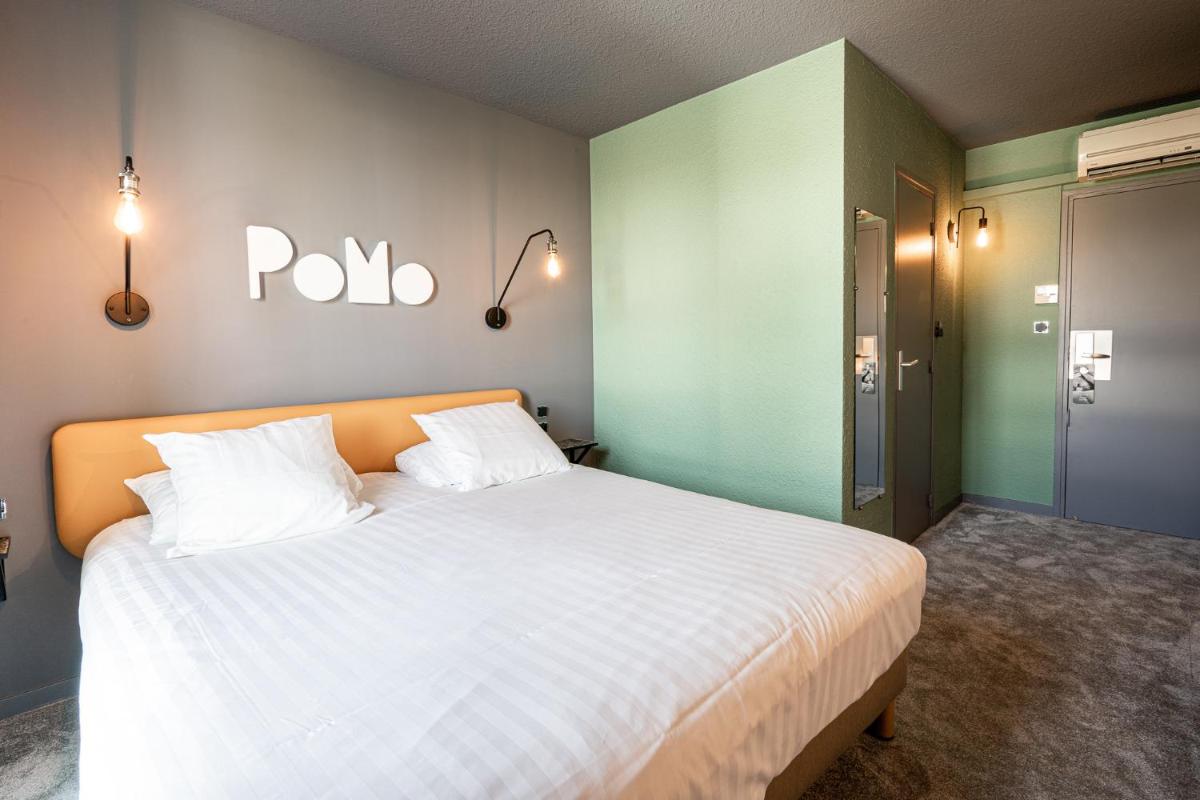 Un ou plusieurs lits dans un hébergement de l'établissement PoMo Hôtel & Restaurant