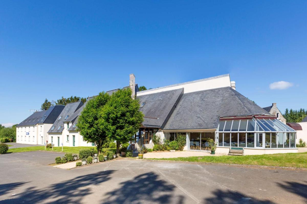 un grand bâtiment blanc avec un toit noir dans l'établissement Best Western Armor Park Dinan et Spa, à Dinan