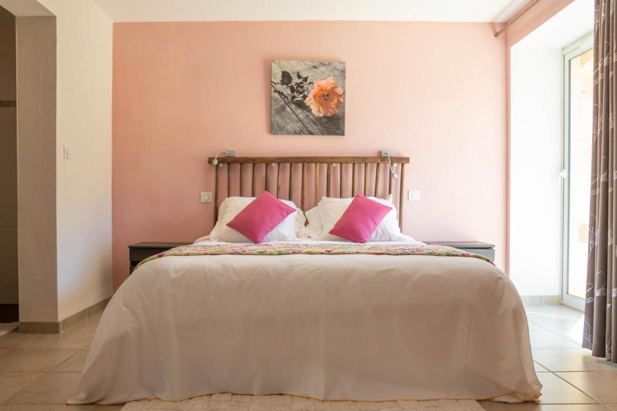 - une chambre avec un grand lit aux murs roses dans l'établissement Domaine de Janis & Spa, au Vigan 49 autres photos