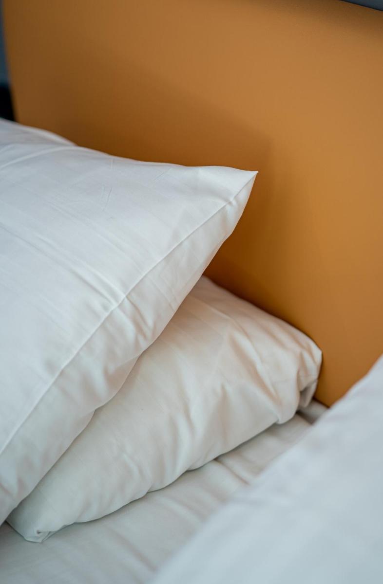 Un ou plusieurs lits dans un hébergement de l'établissement PoMo Hôtel & Restaurant