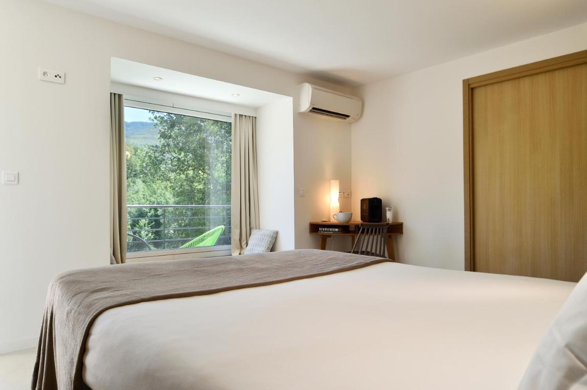 une chambre avec un grand lit et une grande fenêtre dans l'établissement Artemisia Boutique Hotel, à Bastelica 84 autres photos