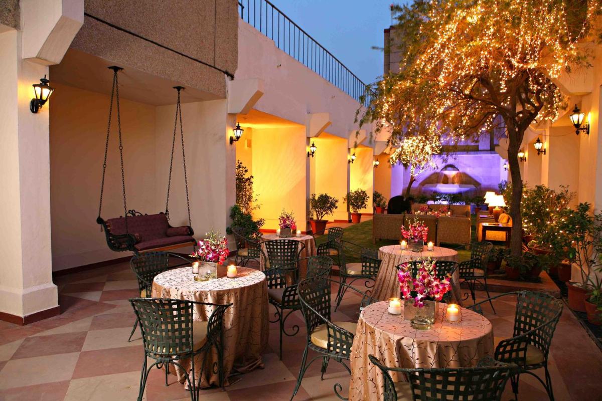 a patio with tables and chairs with candles and lights at Eros Hotel New Delhi, Nehru Place in New Delhi a patio with tables and chairs with candles and lights at Eros Hotel New Delhi, Nehru Place in New Delhi