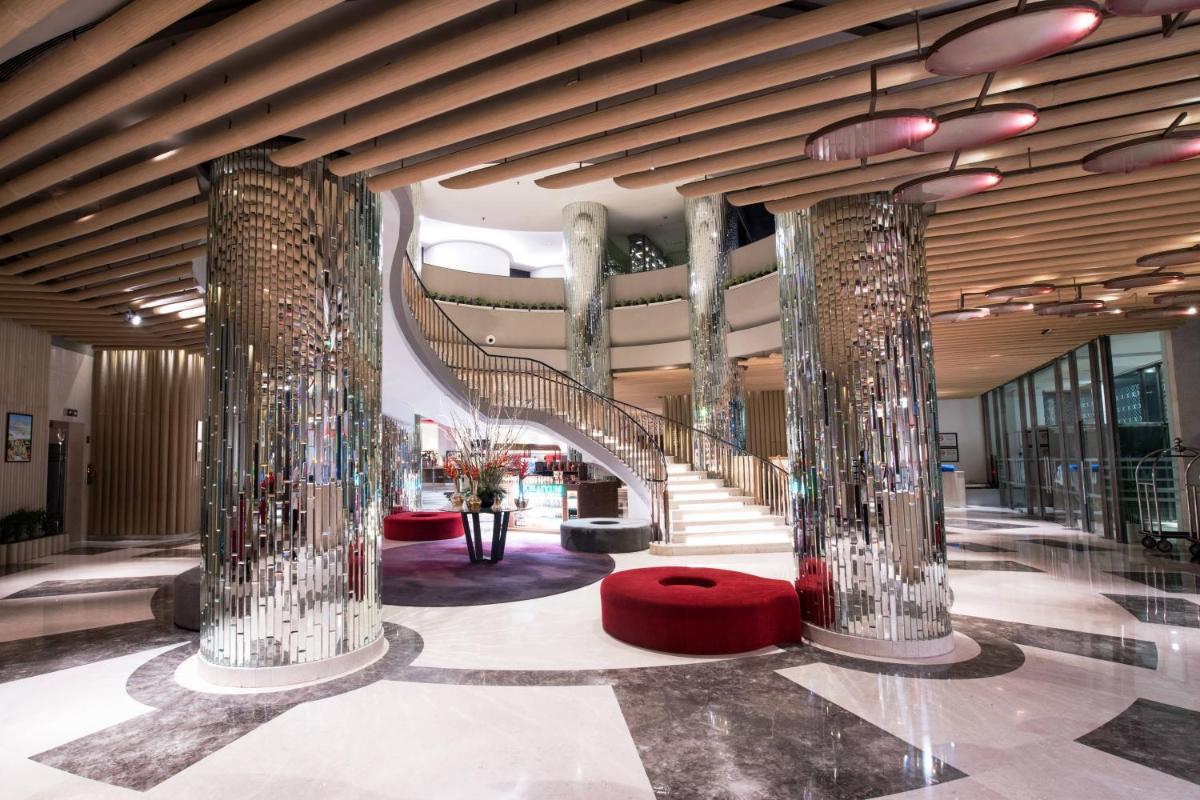 a lobby with a spiral staircase in a building at Welcomhotel by ITC Hotels, Dwarka, New Delhi in New Delhi a lobby with a spiral staircase in a building at Welcomhotel by ITC Hotels, Dwarka, New Delhi in New Delhi