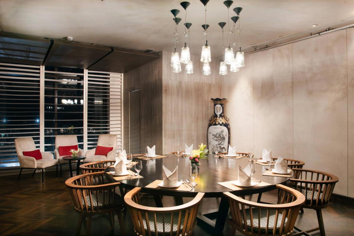 a dining room with a table and chairs and a vase at Welcomhotel by ITC Hotels, Dwarka, New Delhi in New Delhi a dining room with a table and chairs and a vase at Welcomhotel by ITC Hotels, Dwarka, New Delhi in New Delhi