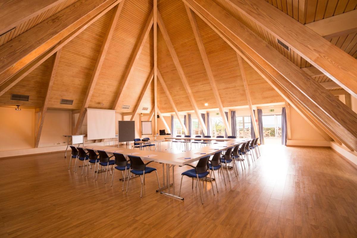 Una gran sala de conferencias con una mesa larga y sillas. en ROBINSON ESQUINZO PLAYA - All Inclusive, en Morro del Jable