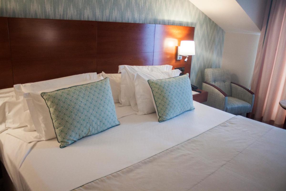 Cama o camas de una habitación en Hotel Carlos I Silgar