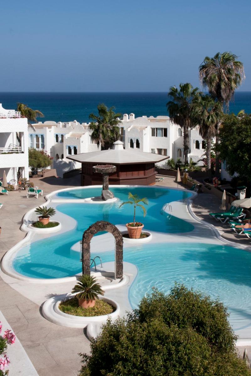 Una gran piscina con el océano al fondo en Sotavento Beach Club, en Costa Calma