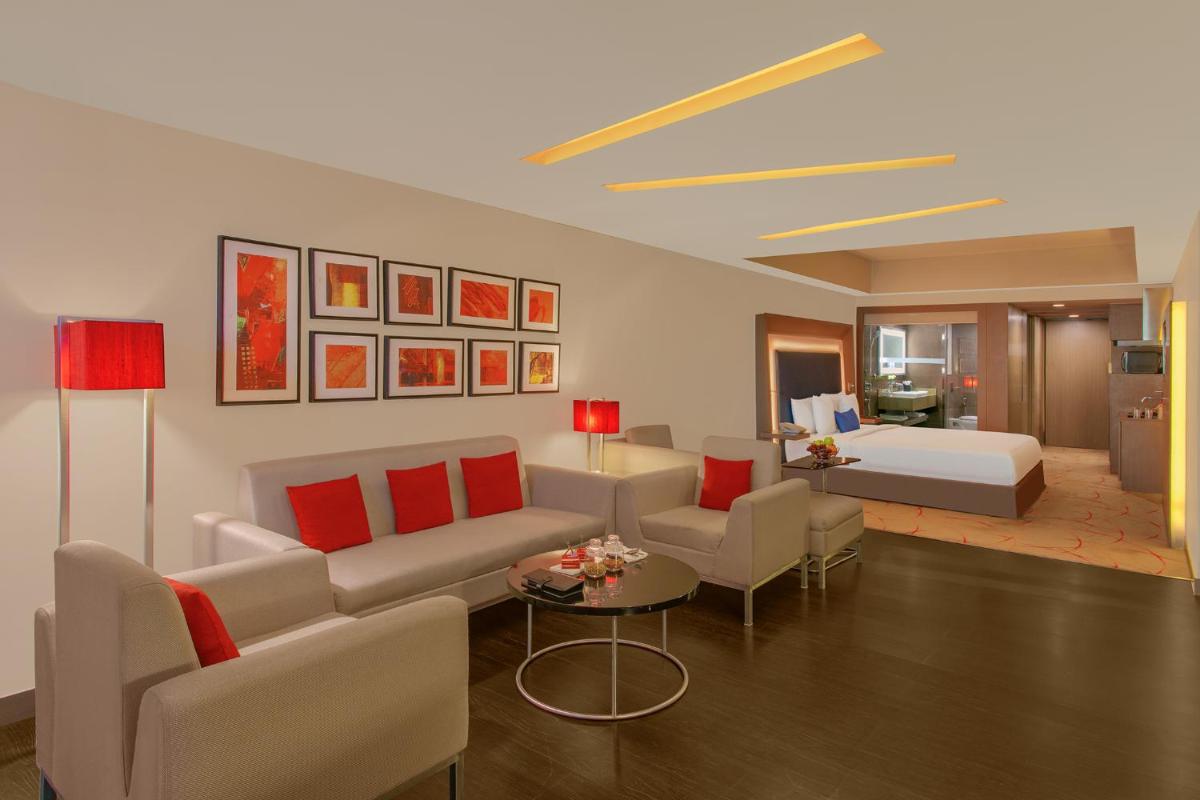 a living room with a couch and a bed at Novotel Ahmedabad in Ahmedabad