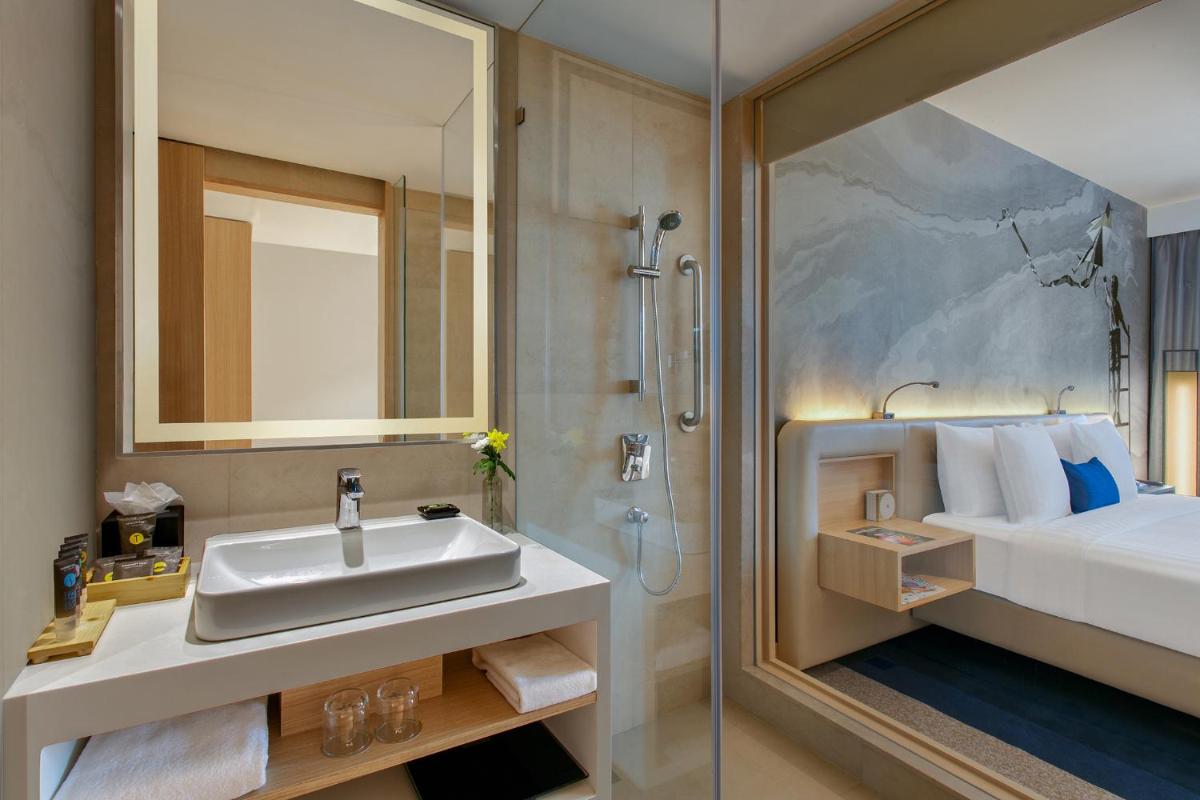 a bathroom with a sink and a shower at Novotel Ahmedabad in Ahmedabad