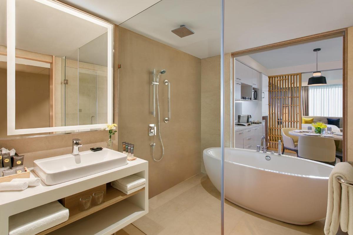 a bathroom with a tub and a sink and a shower at Novotel Ahmedabad in Ahmedabad